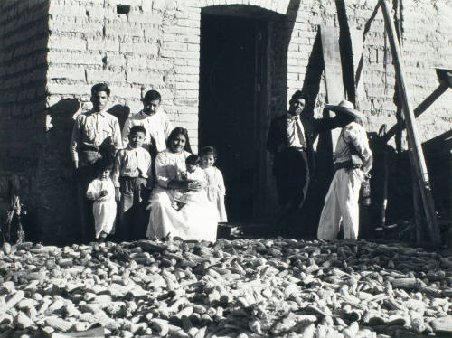Familia campesina en la puerta de una casa. Impresión de negativo original del Comitato Tina Modotti. Trieste, Italia.