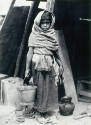 Niña con cubeta cargando agua. Impresión de negativo original del Comitato Tina Modotti. Trieste, Italia.