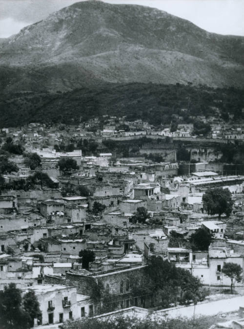 Vista de un pueblo con montañas atrás. Impresión de negativo original del Comitato Tina Modotti. Trieste, Italia.